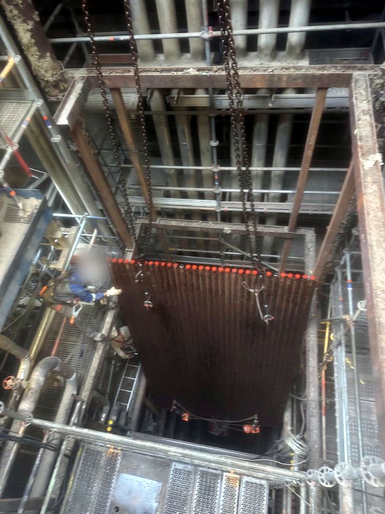 Panneau de tubes descendu dans la chaudière et guidé par un compagnon harnaché