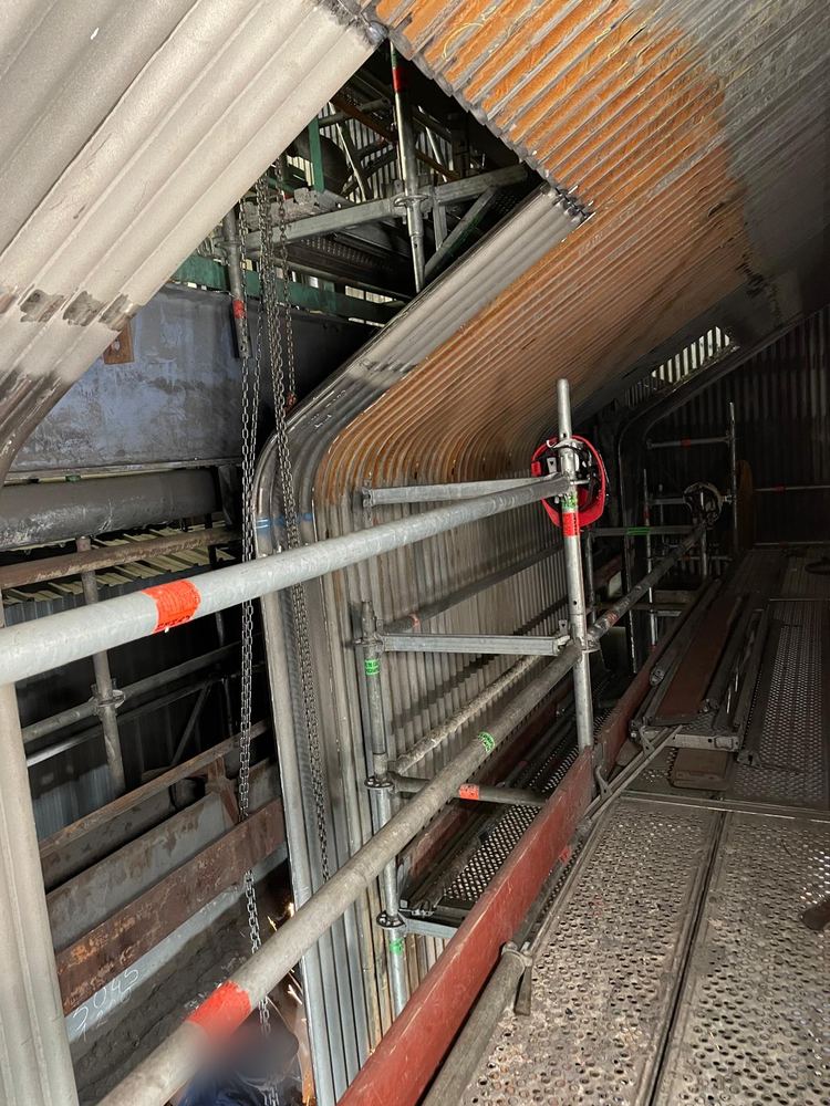 Écran de tubes cintré, accès par échafaudage